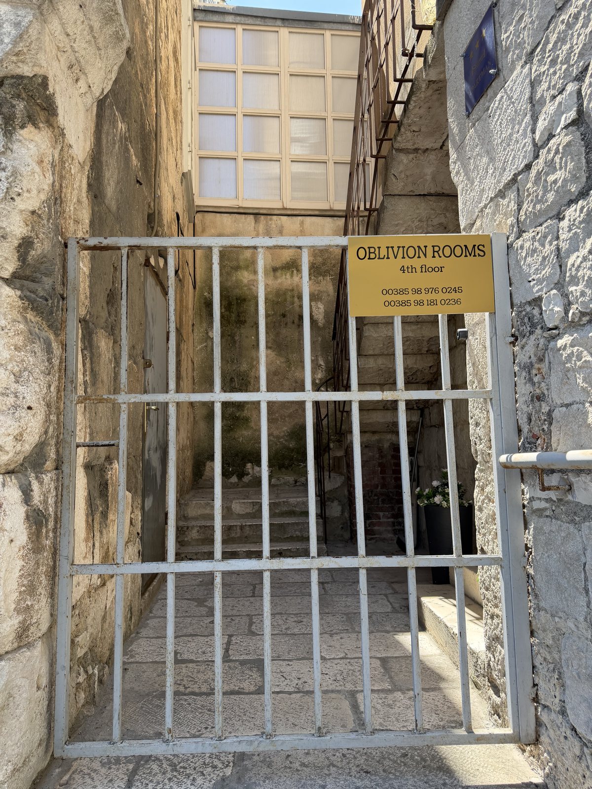 The white gate with Oblivion Rooms sign